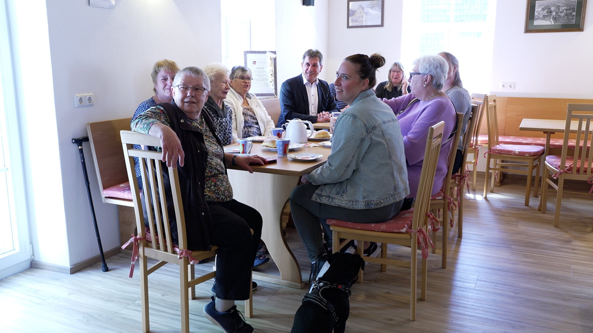 Menschen sitzen um Tisch in Milchhaus