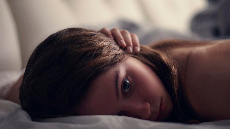 Eine Jugendliche liegt erschöpft im Bett (Symbolbild). | Bild: picture alliance / Bildagentur-online/Blend Images | Blend Images/Vladimir Serov Eine Jugendliche liegt erschöpft im Bett (Symbolbild).