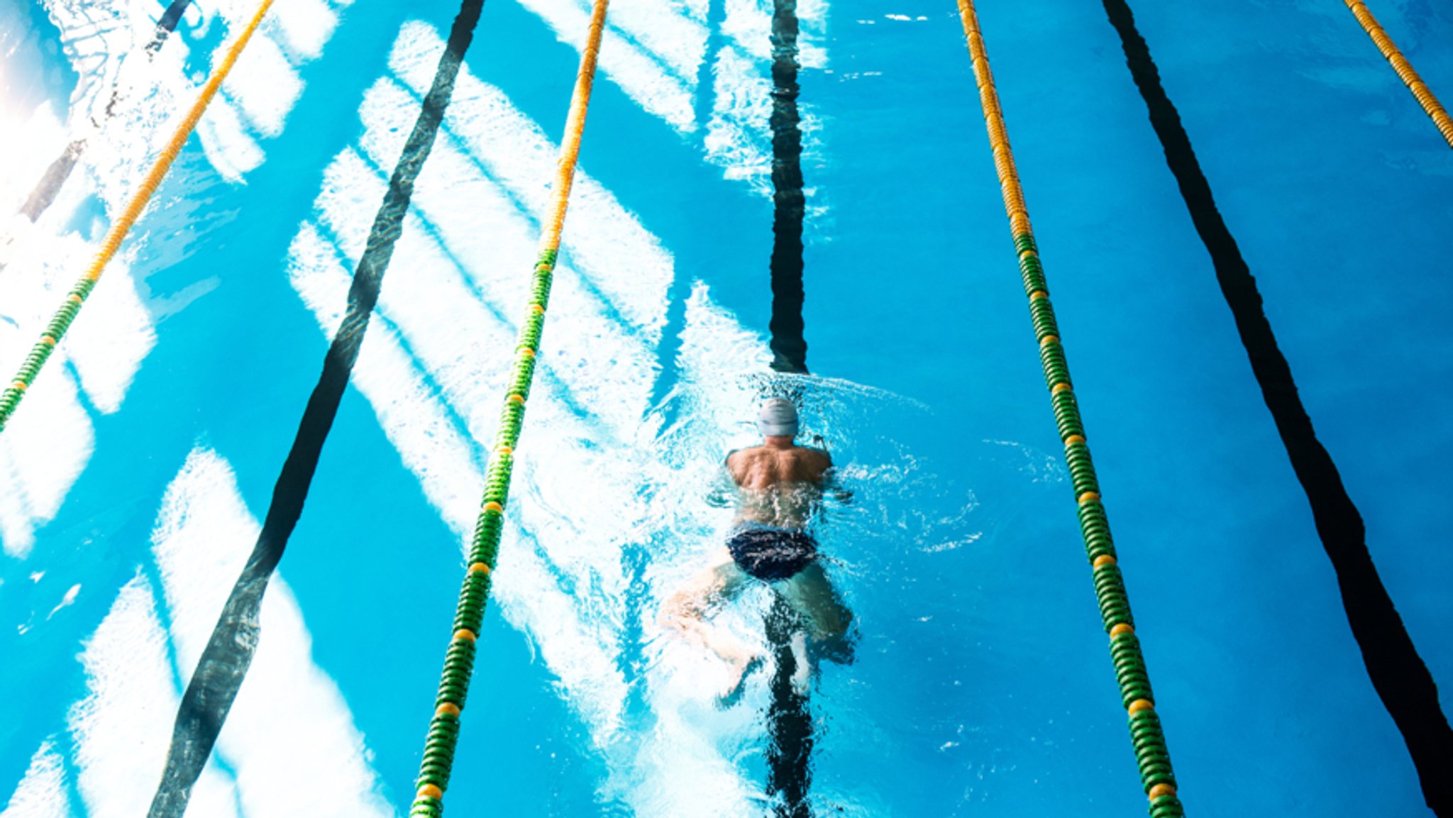 Ein Mann schwimmt in einem Hallenbad