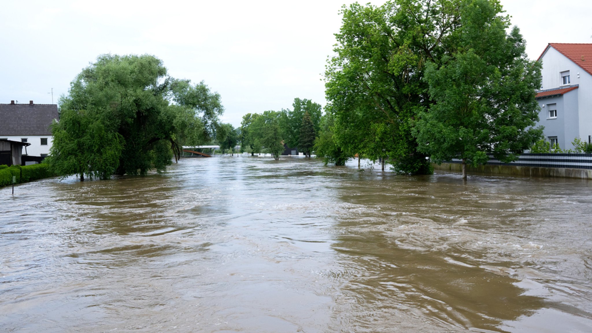 Die Paar hat braunes Hochwasser. Sie fließt durch den Ortskern von Reichertshofen.