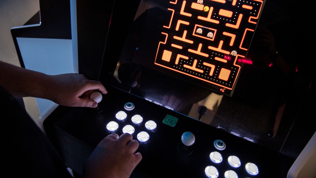 Ein Mann spielt "Ms. Pac-Man" auf einem Arcade-Automaten.
