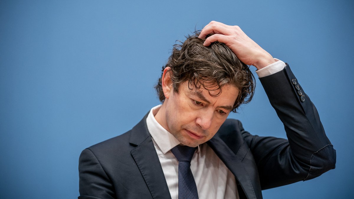 Christian Drosten berührt mit seiner Hand den Kopf und schaut zum Boden | Bild: Michael Kappeler / POOL / AFP Christian Drosten berührt mit seiner Hand den Kopf und schaut zum Boden