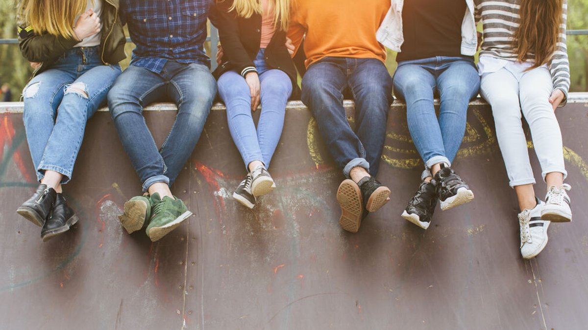 Eine Gruppe Jugendlicher sitzt auf eine Skateboardrampe.