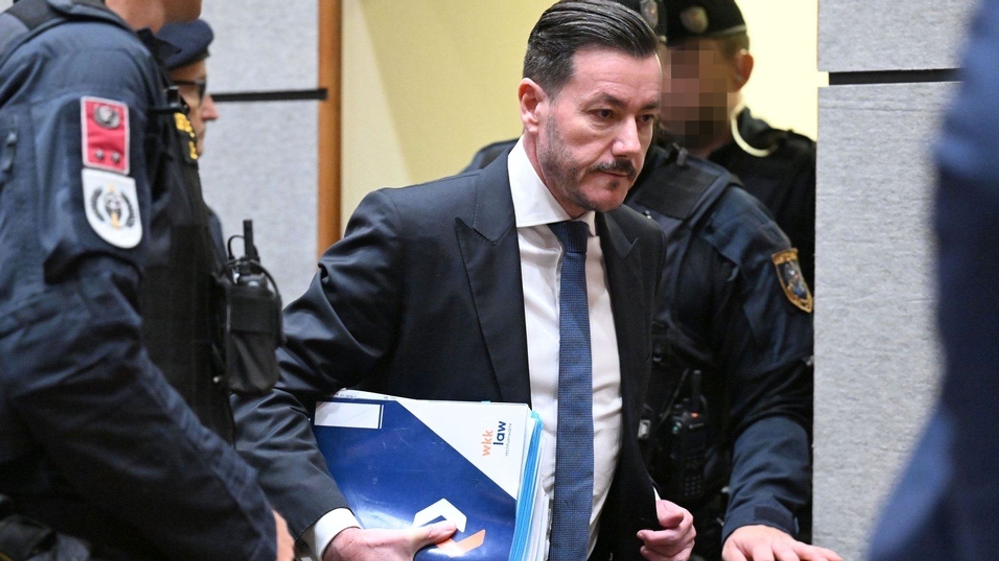 15.10.2025, Österreich, Innsbruck: Der Angeklagte Rene Benko kommt mit Akten zu Beginn des zweiten Verhandlungstags in das Landgericht.