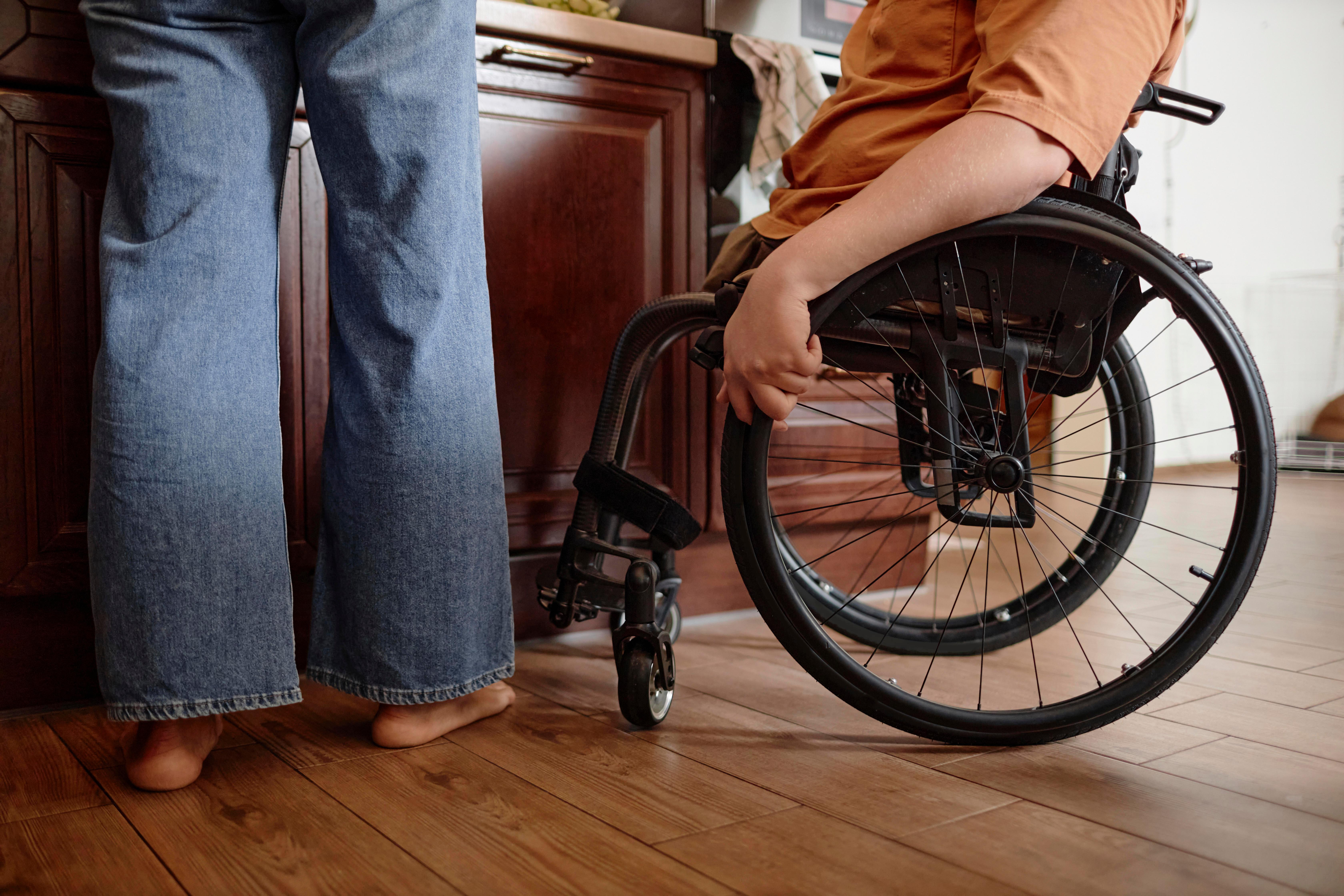 Eine Person im Rollstuhl steht in einer Küche.