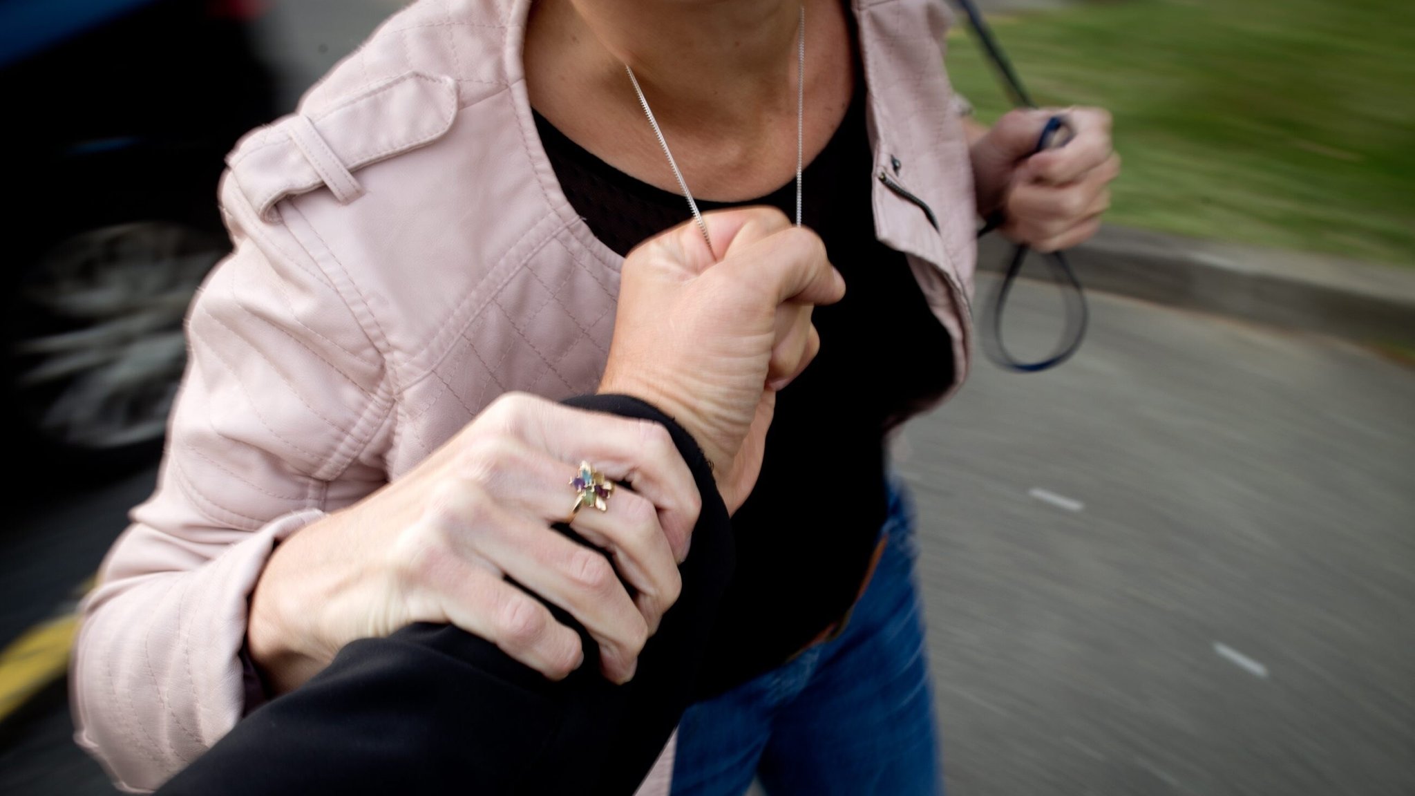 Jemand versucht einer Frau eine Kette vom Hals zu reißen (Archiv- und Symbolbild)