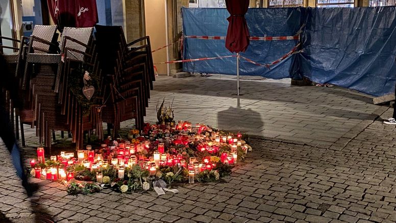 Blumen und Kerzen stehen auf dem Boden vor dem Tatort.  | Bild:BR/Andi Ebert