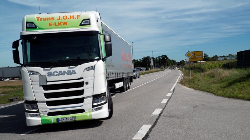 Auf den Straßen gehören E-Autos mittlerweile zum gewohnten Bild. E-Lastwagen dagegen sind derzeit noch eine Ausnahme. Ein Spediteur versucht es elektrisch. | Bild: BR/Christian Riedl Auf den Straßen gehören E-Autos mittlerweile zum gewohnten Bild. E-Lastwagen dagegen sind derzeit noch eine Ausnahme. Ein Spediteur versucht es elektrisch.