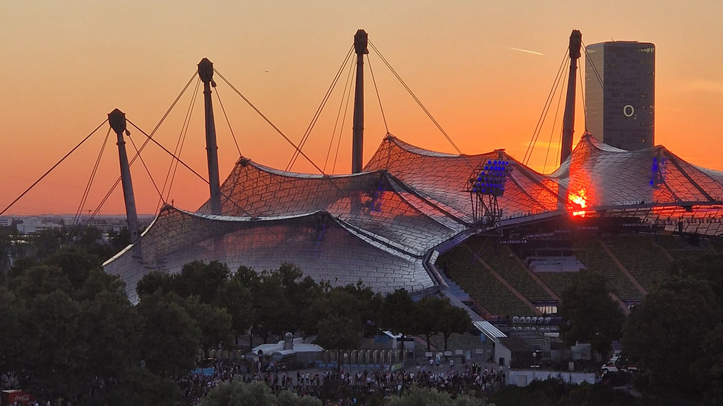 Blick auf den Münchner Olympiapark, das Dach des Olympiastadions und den O2-Tower im Sonnenuntergang bei der Eröffnung der European Championships.