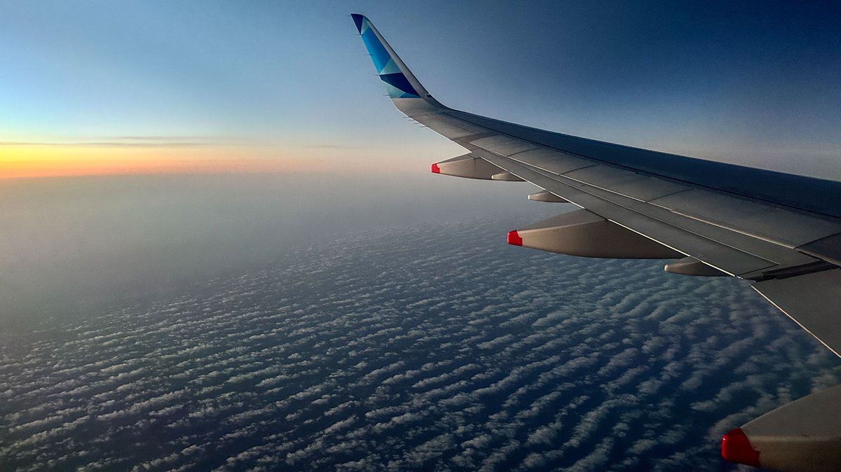 Die Tragfläche eines Flugzeugs über den Wolken