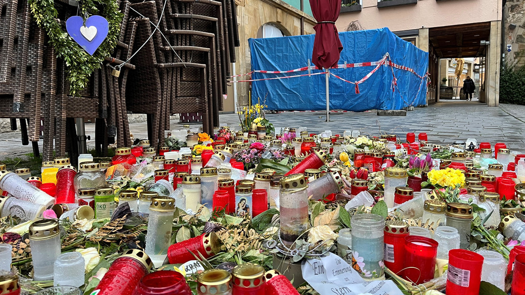 Kerzen und Blumen stehen auf dem Boden einer Straße. | Bild: BR/Richard Padberg Kerzen und Blumen stehen auf dem Boden einer Straße.