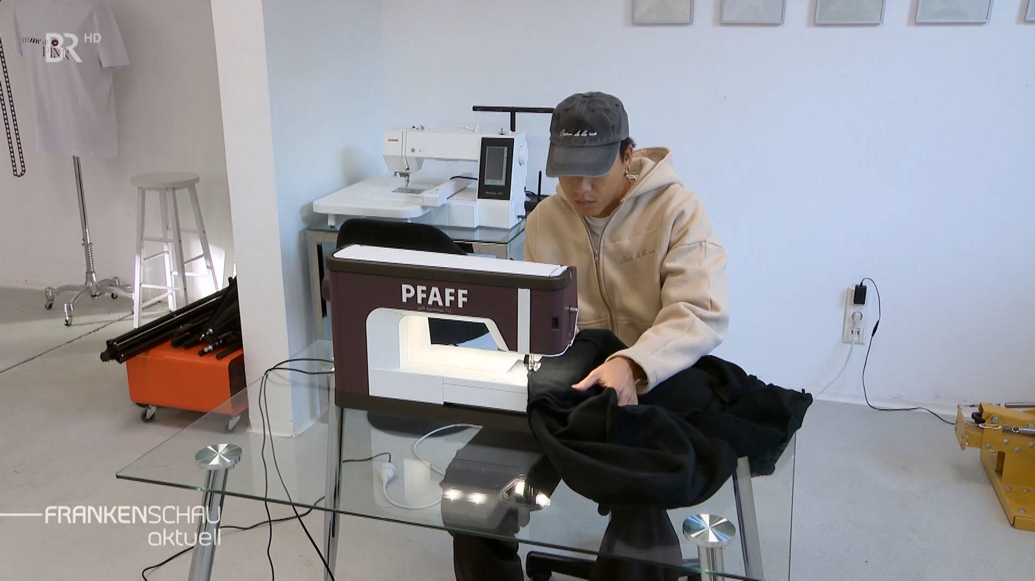 Ein junger Mann sitzt an einer Nähmaschine und näht. | Bild: BR-Studio Franken Ein junger Mann sitzt an einer Nähmaschine und näht.