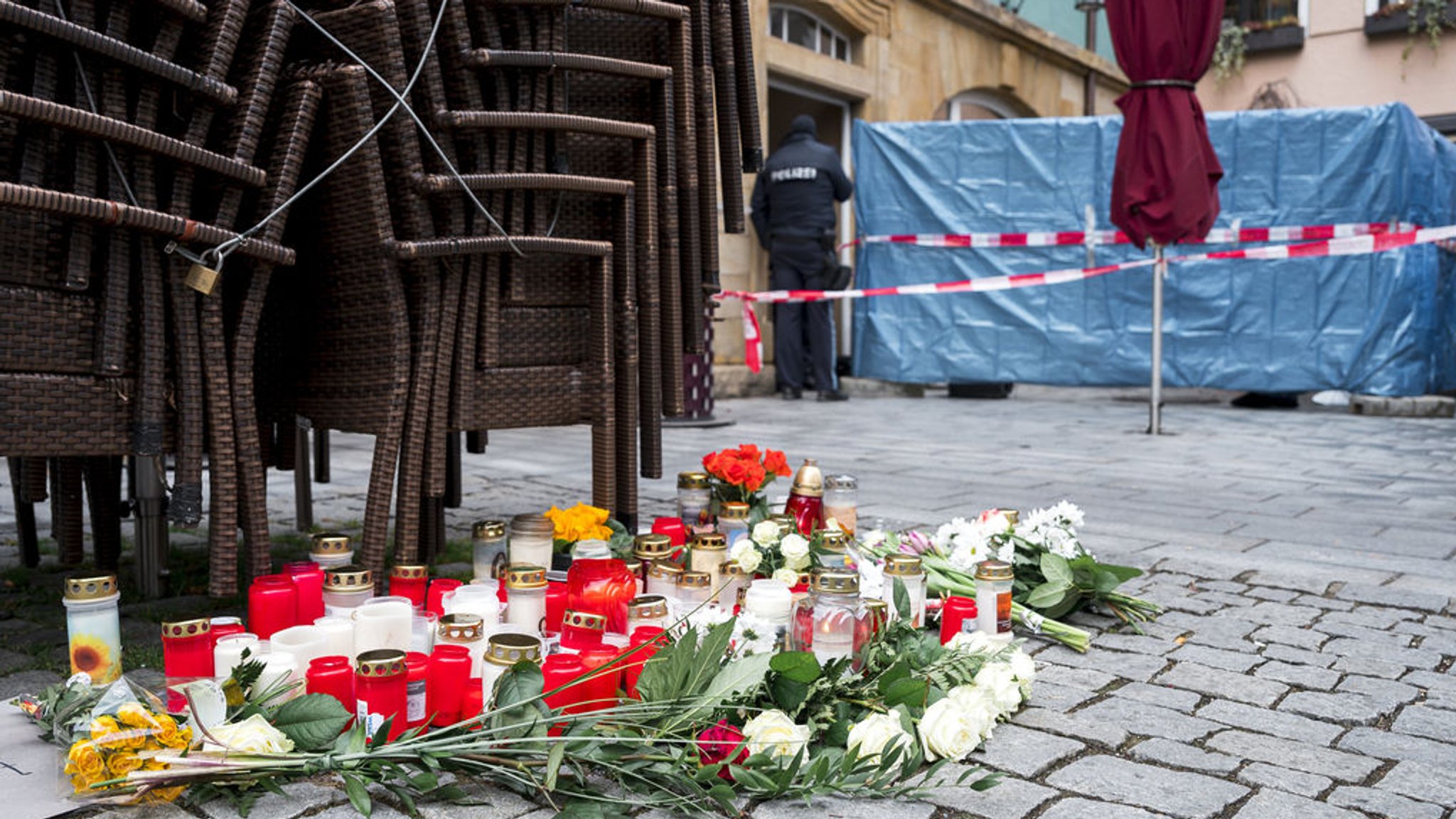 ARCHIV - 13.03.2023, Bayern, Lichtenfels: Auf dem Platz vor dem Blumengeschäft, in dem im März 2023 eine Mitarbeiterin tot aufgefunden wurde, sind Blumen und Kerzen niedergelegt. Spaziergänger hatten die tote 50-Jährige in dem Blumenladen in der Lichtenfelser Innenstadt entdeckt. (zu dpa: «Blumenverkäuferin getötet - Prozess gegen 18-Jährigen beginnt») Foto: Daniel Vogl/dpa +++ dpa-Bildfunk +++