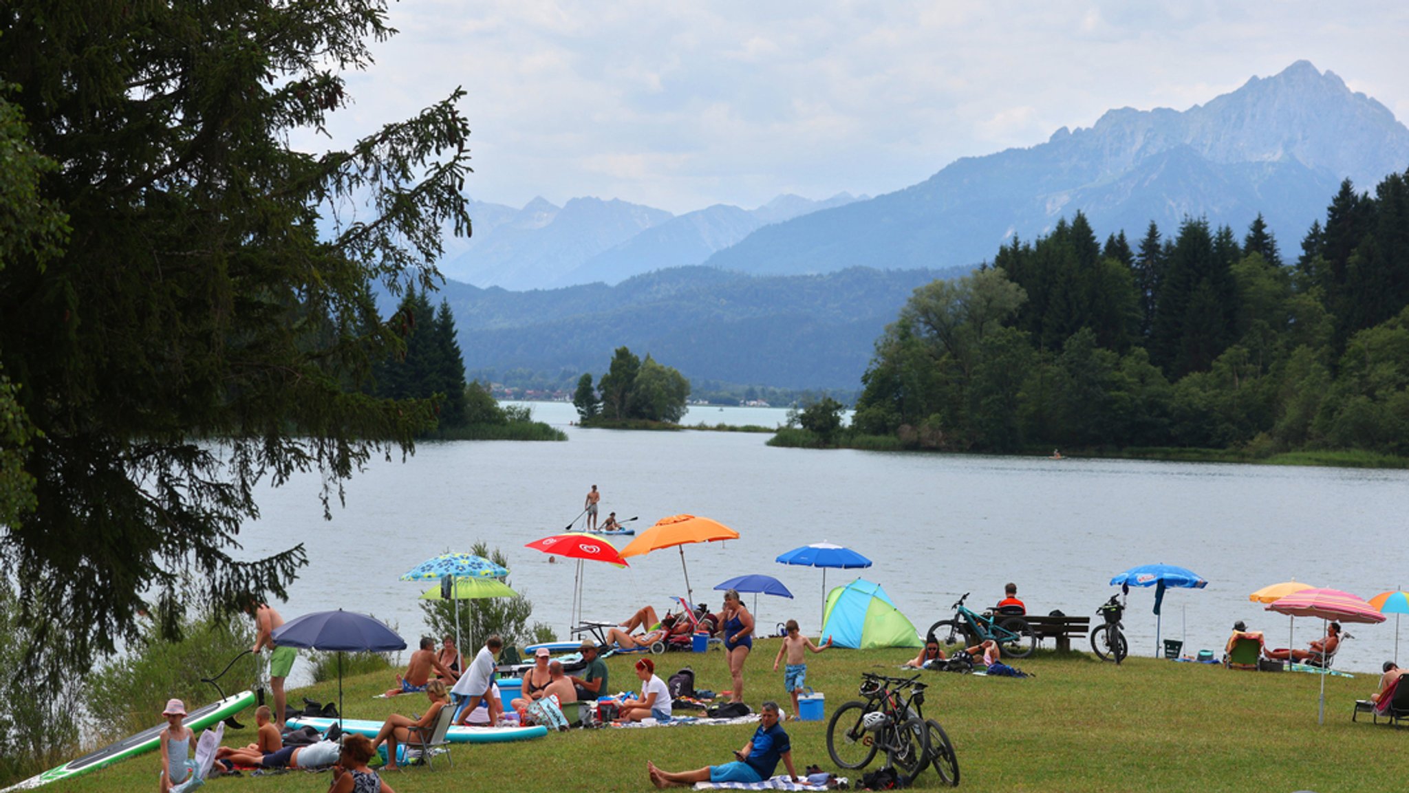 Archivbild vom 5.7.23: Ausflügler in einem Strandbad des am Alpenrand gelegenen Illasbergsees in Bayern.