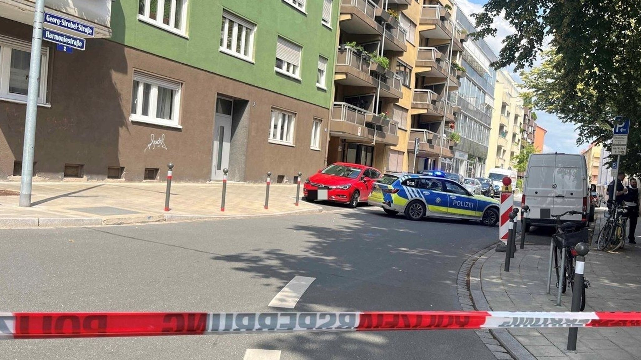 Eine Straße in Nürnberg ist mit einem rot-weißen-Band gesperrt, dahinter parkt ein Polizeiauto