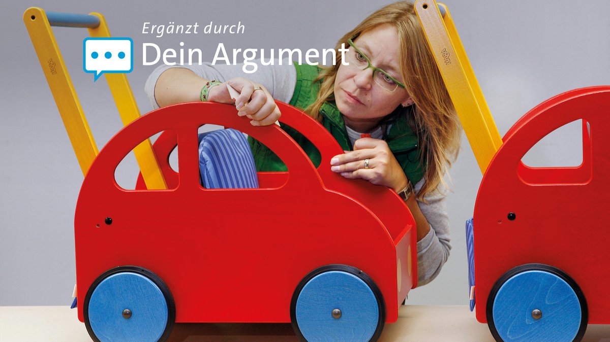 Eine Mitarbeiterin des Spielzeugherstellers Haba kontrolliert in Bad Rodach ein Spielzeugauto für Kinder.