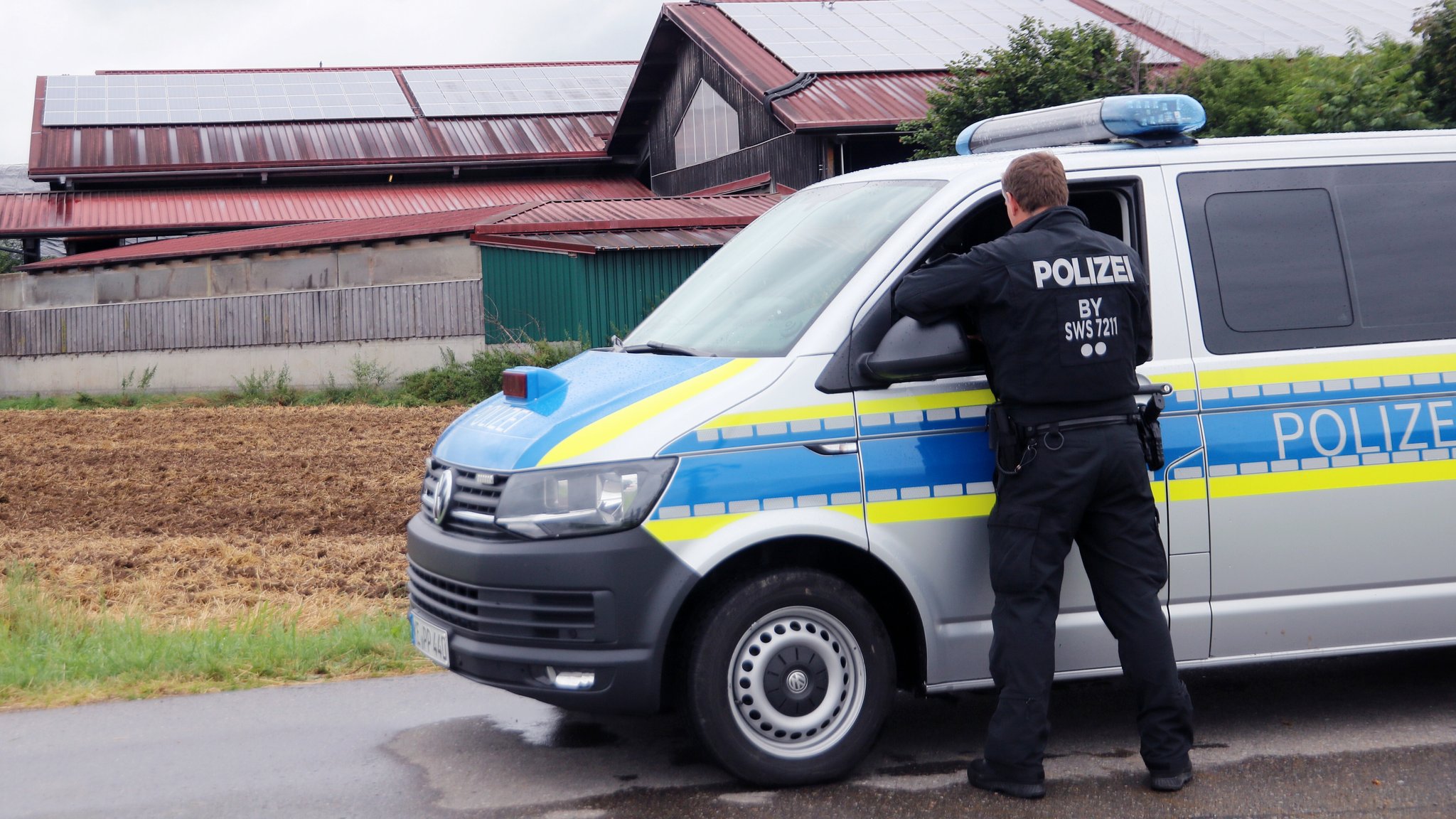 (Archivbild) Ein Polizei-Mannschaftswagen steht vor einem landwirtschaftlichen Betrieb im Allgäu.