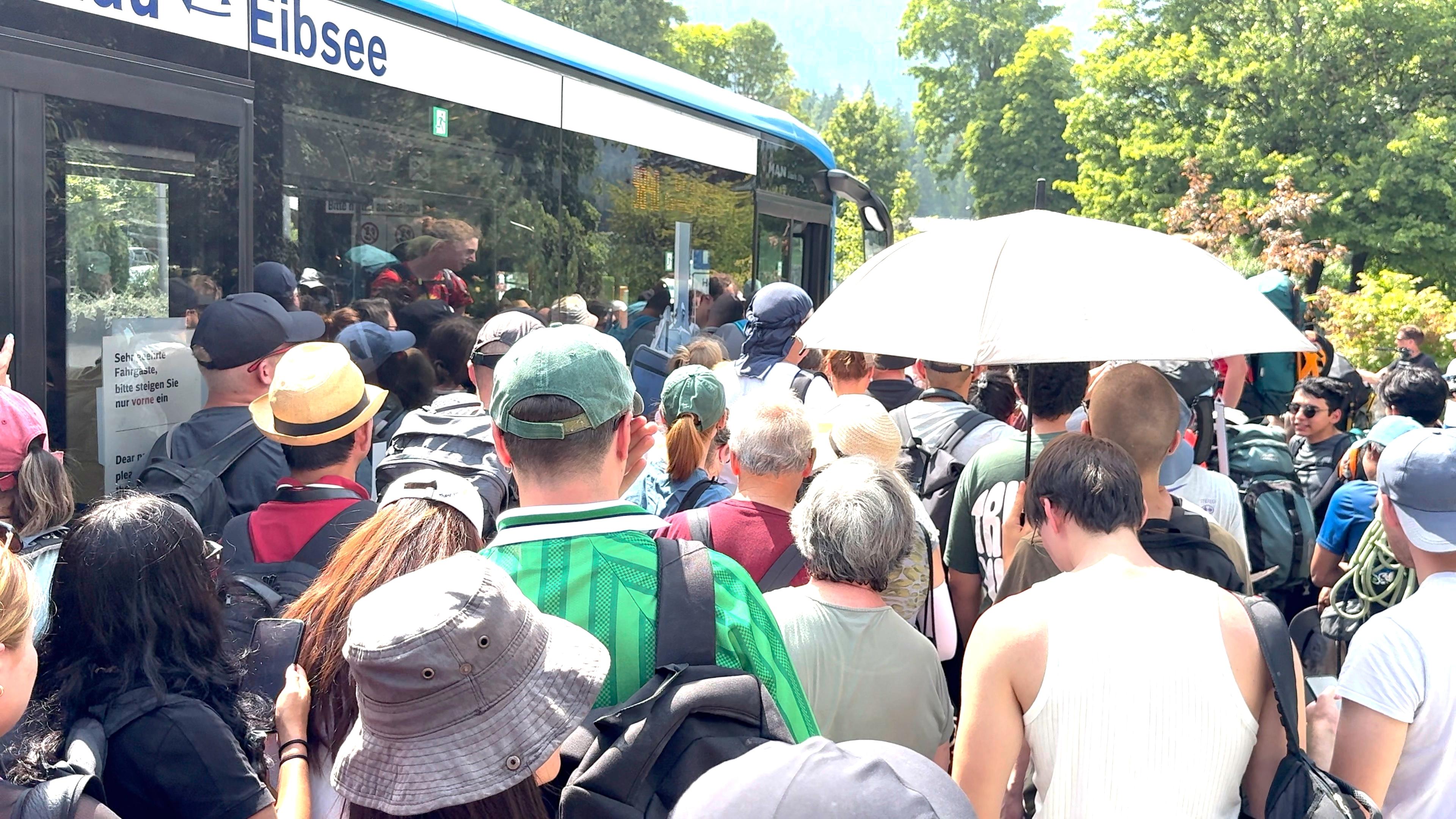 Tumultartige Szenen am Eibsee. Menschen drängeln sich an der Tür des ÖPNV-Busses.