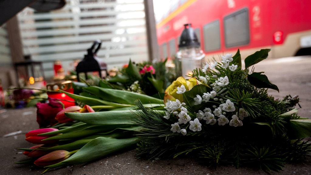 In einem Wartehäuschen am Brokstedter Bahnhof liegen Kerzen und Blumen.