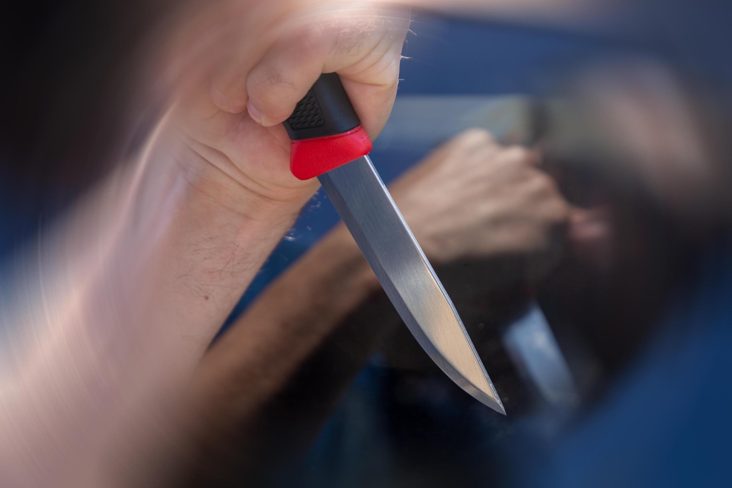 Symbolbild Messerattacke: Nahaufnahme von einem Messer in der Hand eines Mannes