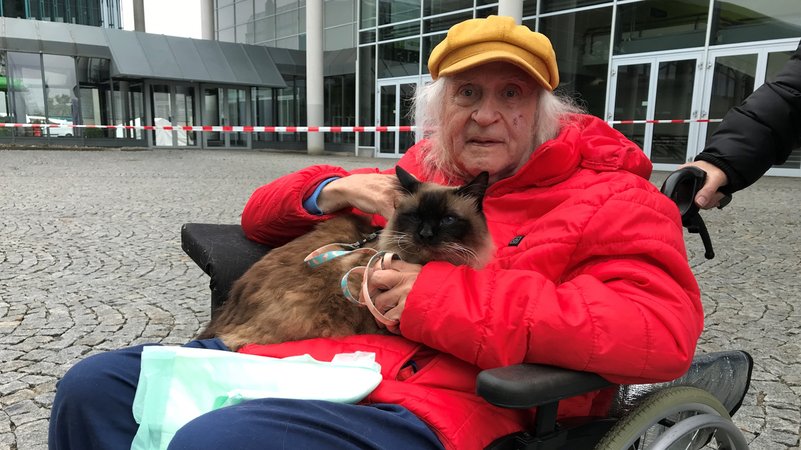 Norbert Hlacer und seine Birmakatze Filou aus Dinkelscherben mussten an der Messe Augsburg übernachten. | Bild: BR/ Barbara Leinfelder Norbert Hlacer und seine Birmakatze Filou aus Dinkelscherben mussten an der Messe Augsburg übernachten.