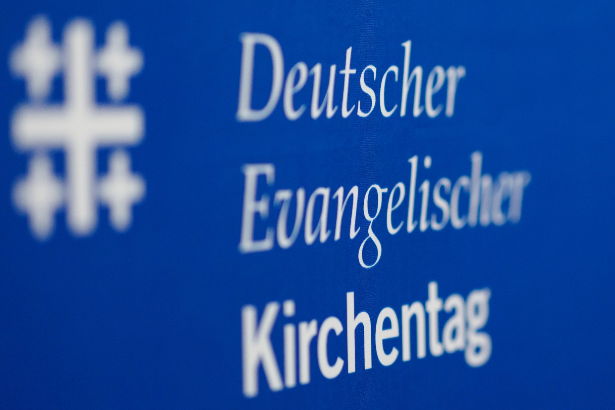 ARCHIV - 16.03.2023, Bayern, Nürnberg: Das Logo des Deutschen Evangelischen Kirchentags ist am Rande der Pressekonferenz zum Programm des 38. Evangelischen Kirchentags zu sehen. Der Kirchentag findet vom 7. bis 11. Juni 2023 in Nürnberg statt. Foto: Daniel Karmann/dpa +++ dpa-Bildfunk +++