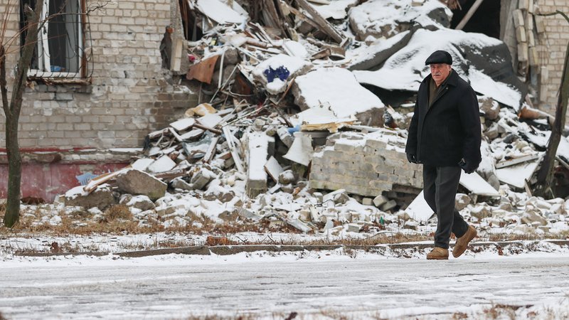 Ein Mann geht an schneebedeckten Fassadentrümmern vorbei | Bild: Alexander Reka/Picture Alliance Ein Mann geht an schneebedeckten Fassadentrümmern vorbei