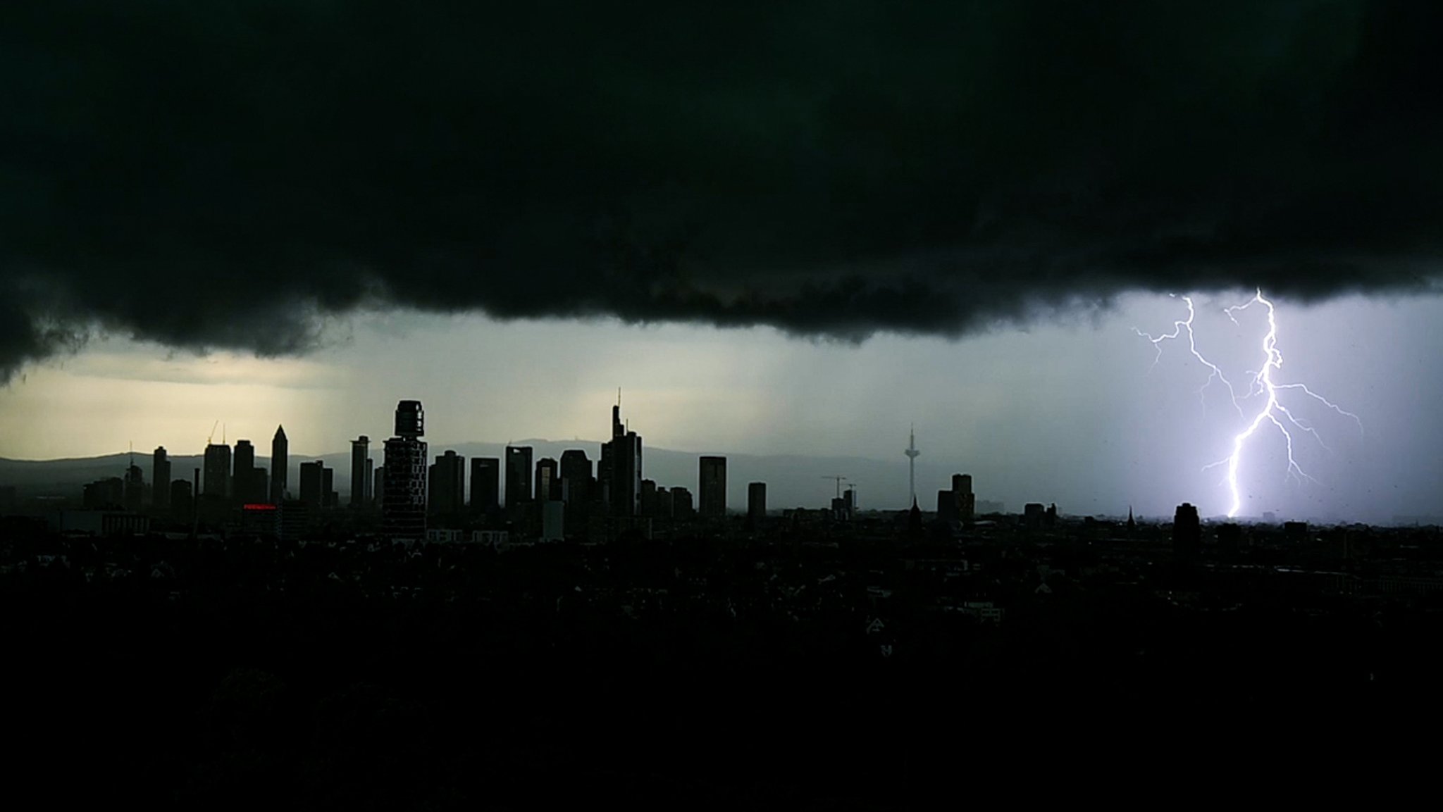 Tiefschwarze Gewitterwolken verdunkeln den Himmel über der Frankfurter Innenstadt und seinen markanten Hochhäusern. 