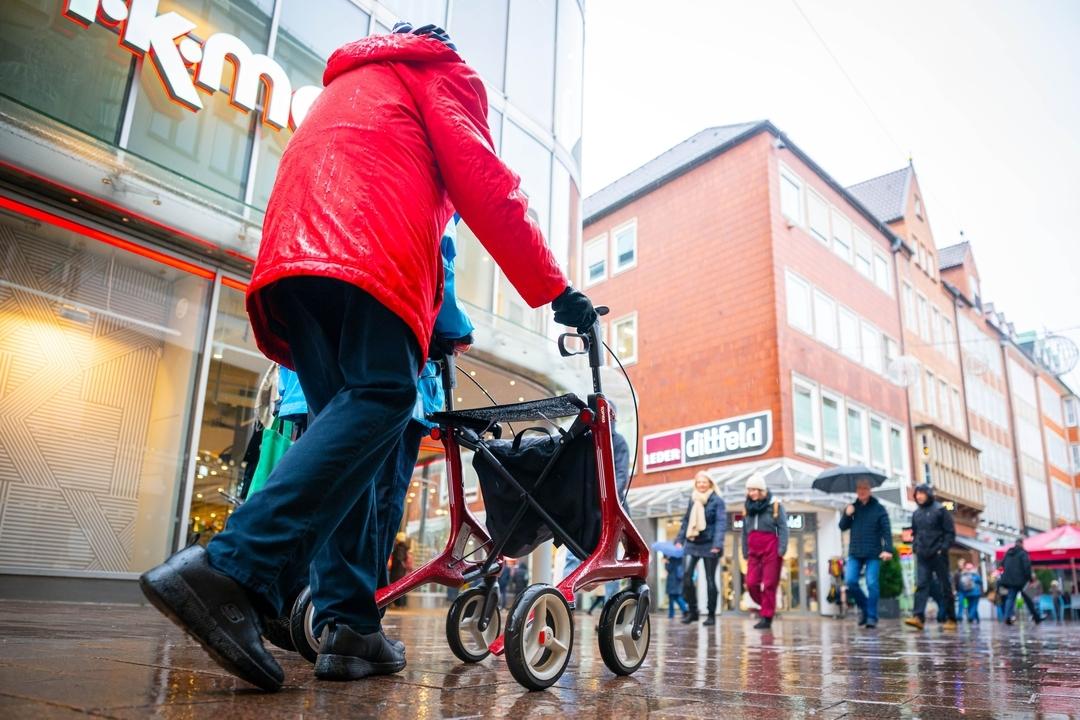 Renter auf regennasser Einkaufsstraße