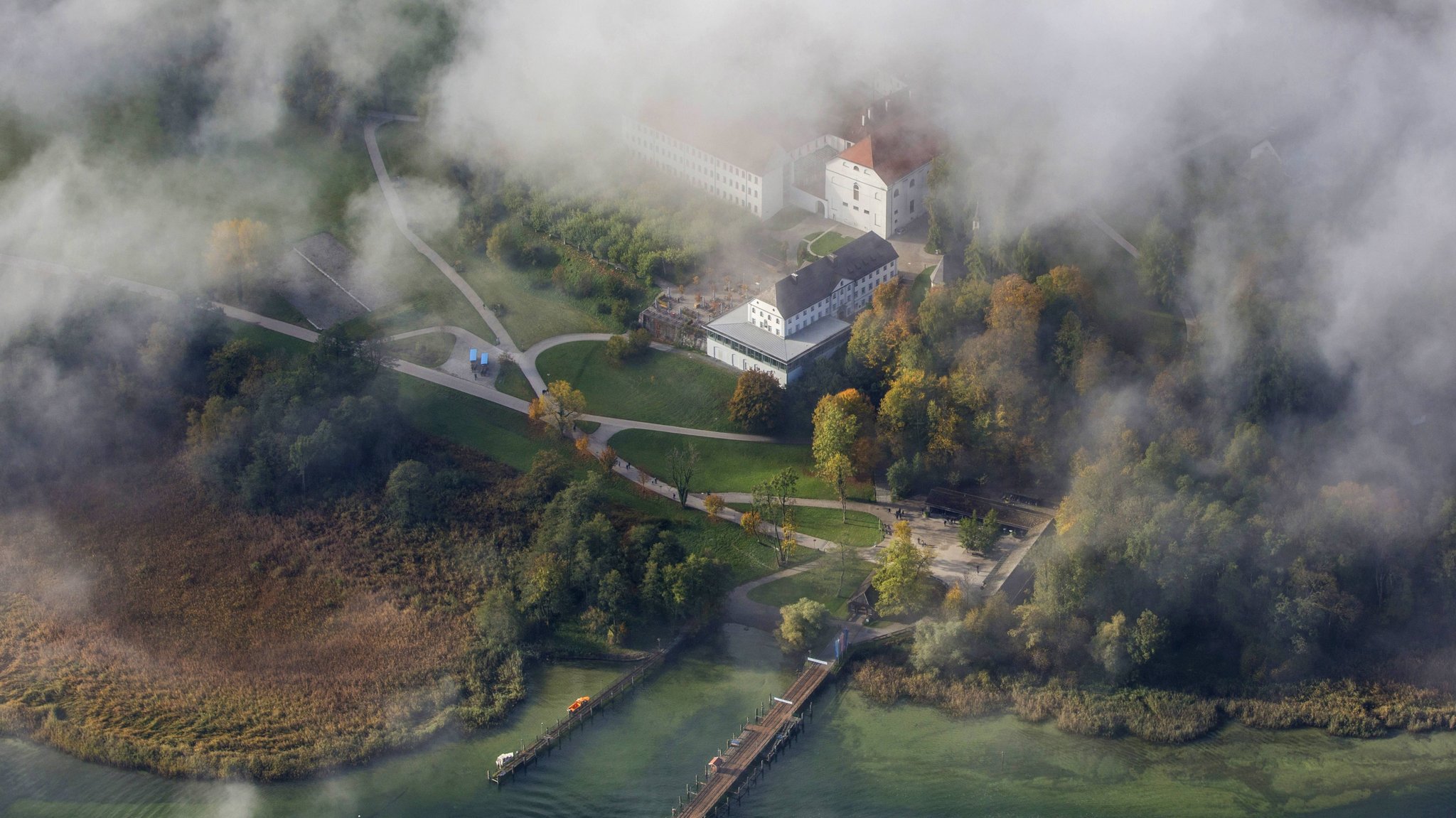 Blick durch die Wolken auf das alte Schloss auf der Insel Herrenchiemsee.