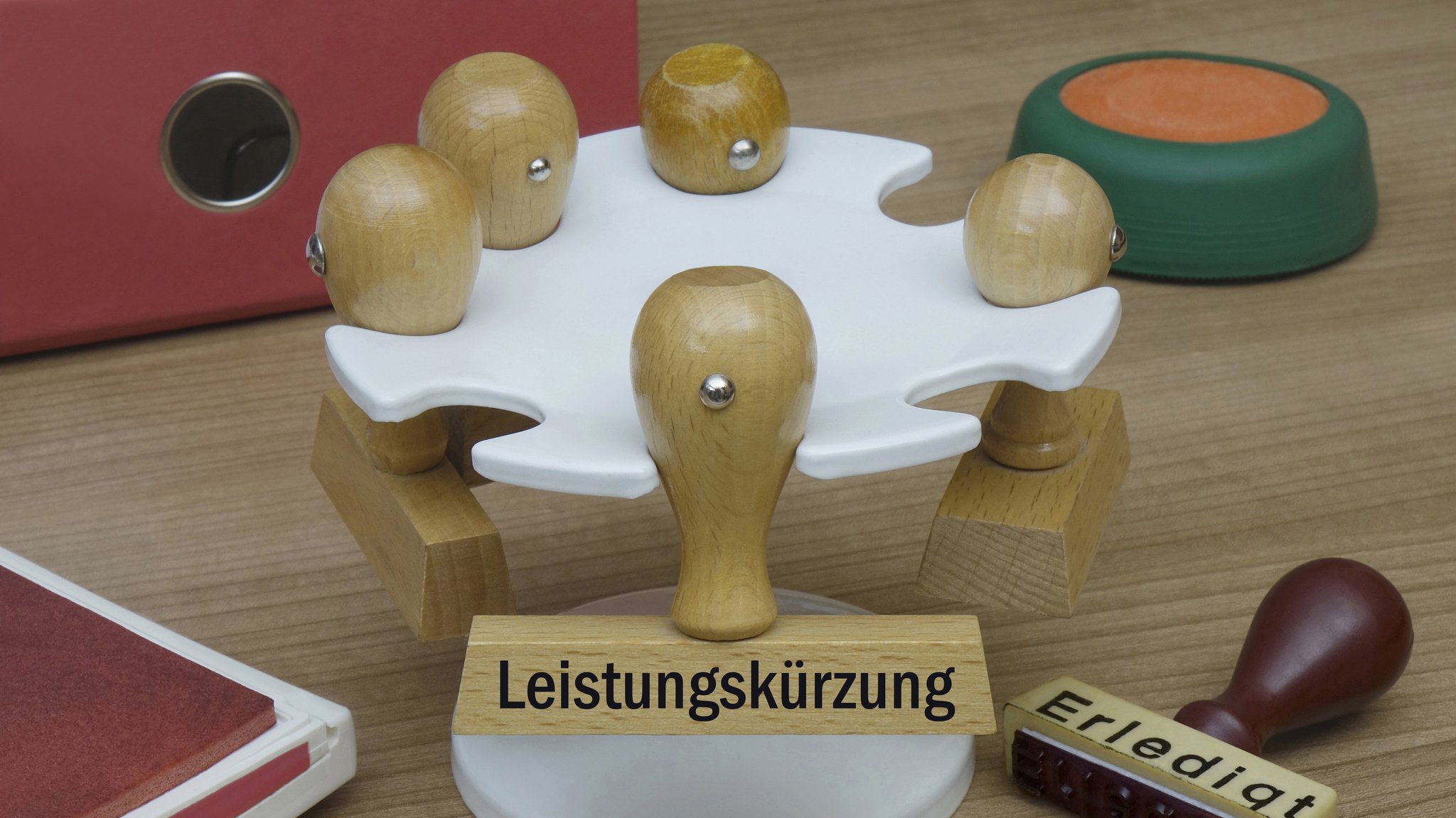 (Symbolbild) An einem Stempelkarussell befinden sich Stempel mit den Schriftzügen "Leistungskürzung" und "Erledigt".