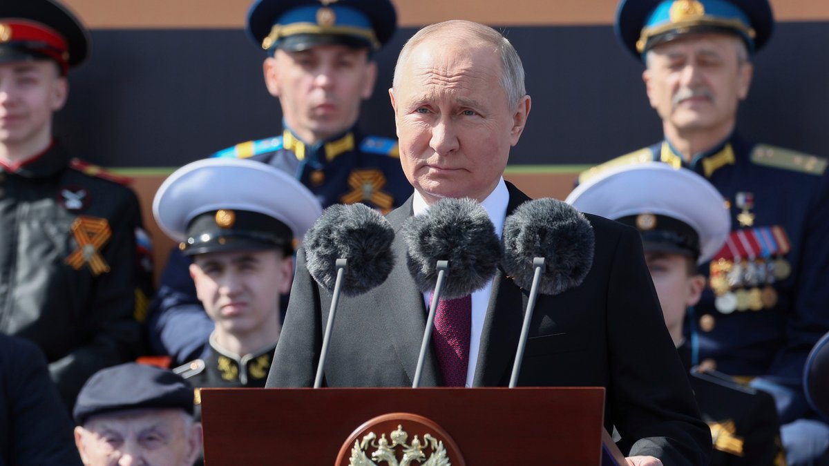Russlands Präsident Putin steht hinter einem Rednerpult. Im Hintergrund sitzen Militärangehörige.