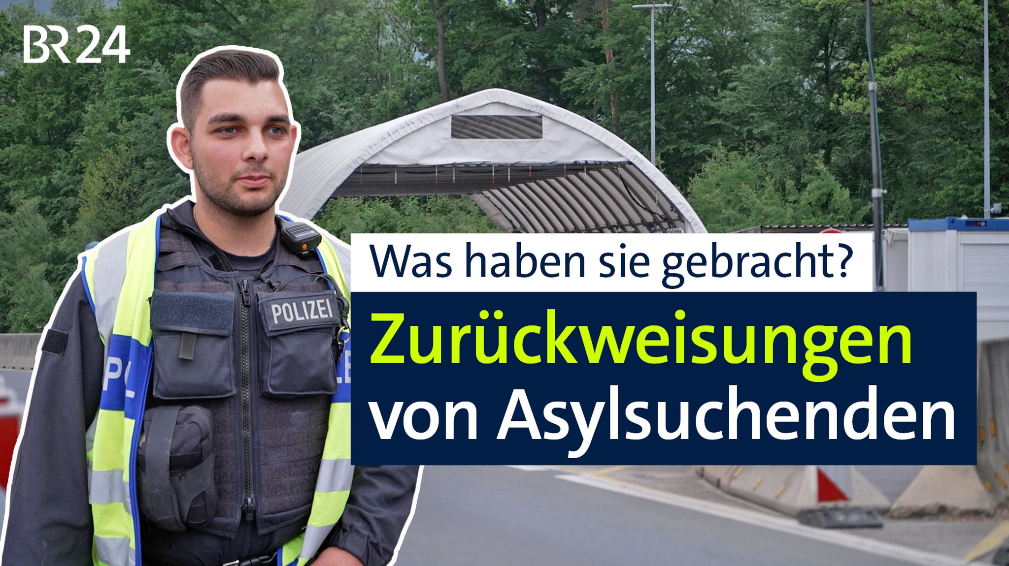 Ein Grenzpolizist steht mit Blick auf den entgegenkommenden Verkehr vor einem weißen Zelt für Grenzkontrollen