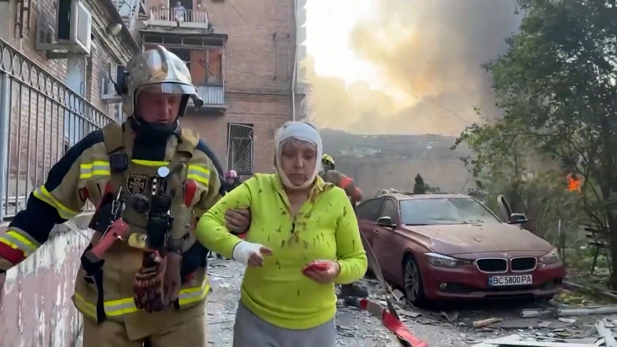 Ein Feuerwehrmann hilft einer verletzten Frau