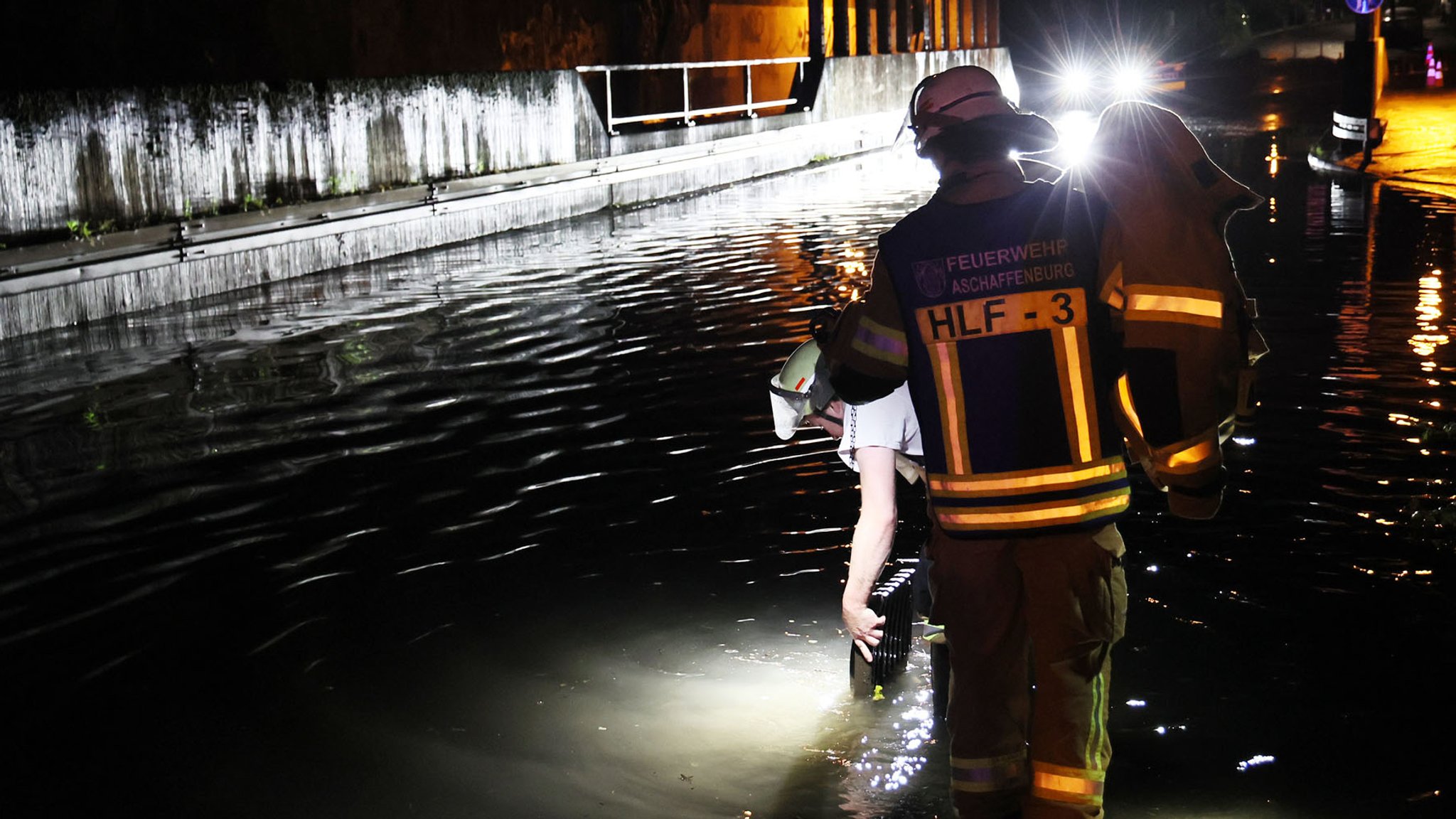 Feuerwehrleute pumpen in Aschaffenburg ein Viadukt leer.