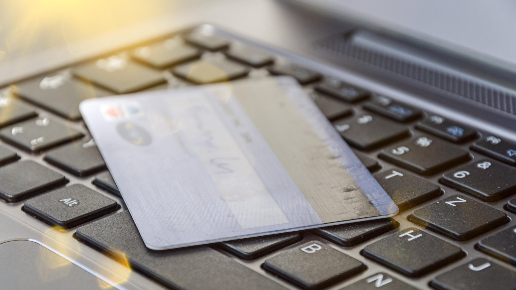 Symbolbild: Kreditkarte auf einer Computertastatur als Symbol für Online-Banking oder Online-Shopping