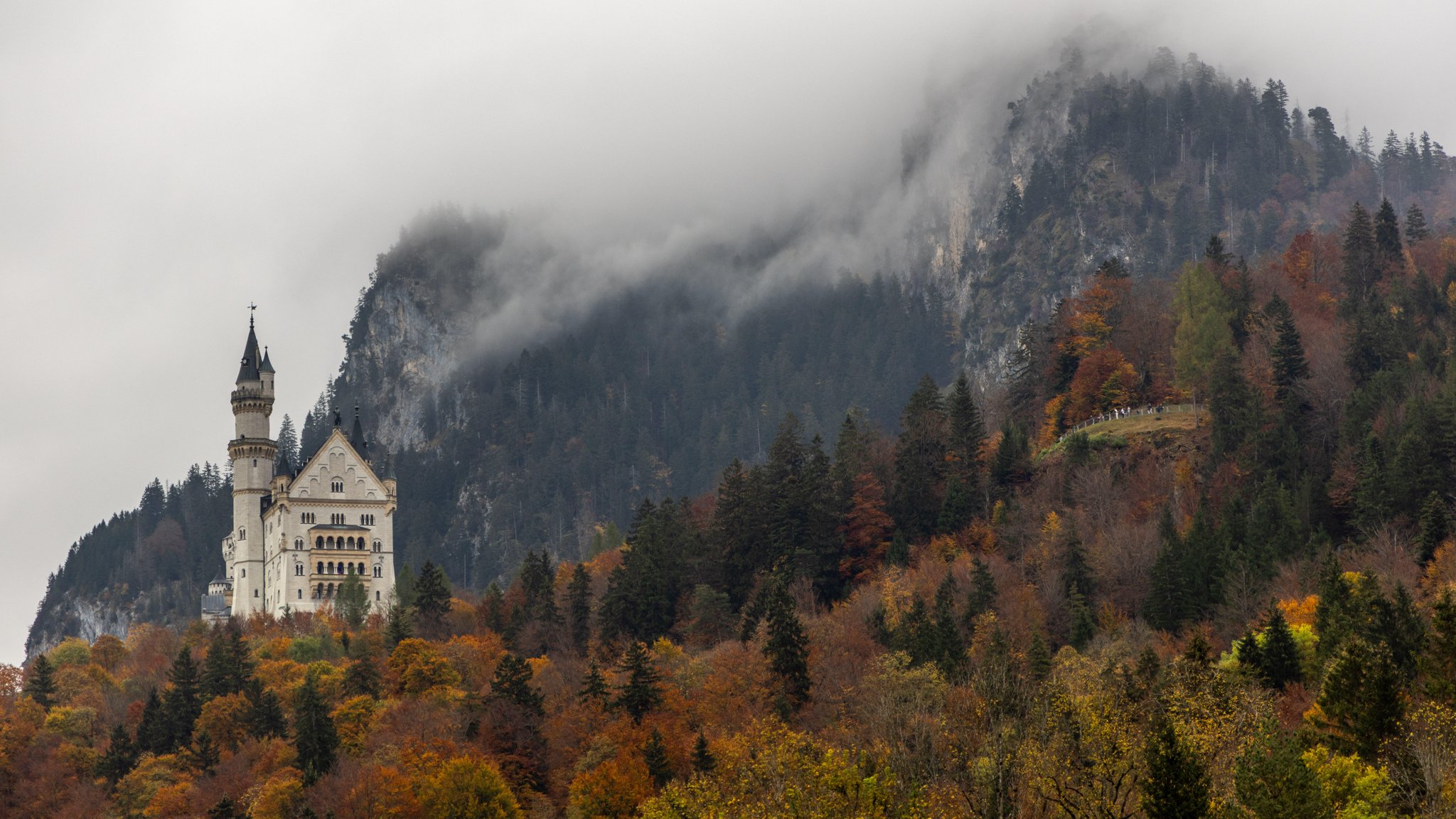 Bei trübem Wetter sind dichte Wolken über Schloss Neuschwanstein zu sehen.