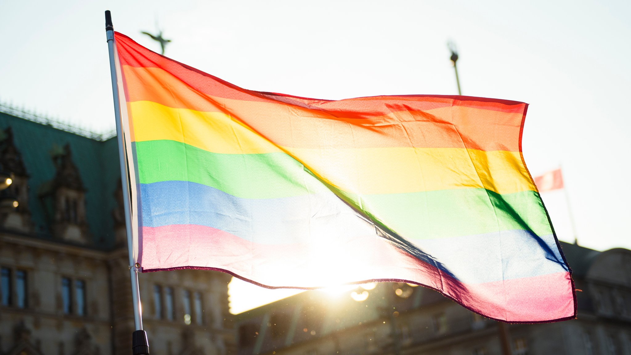 Eine Regenbogenflagge weht im Wind