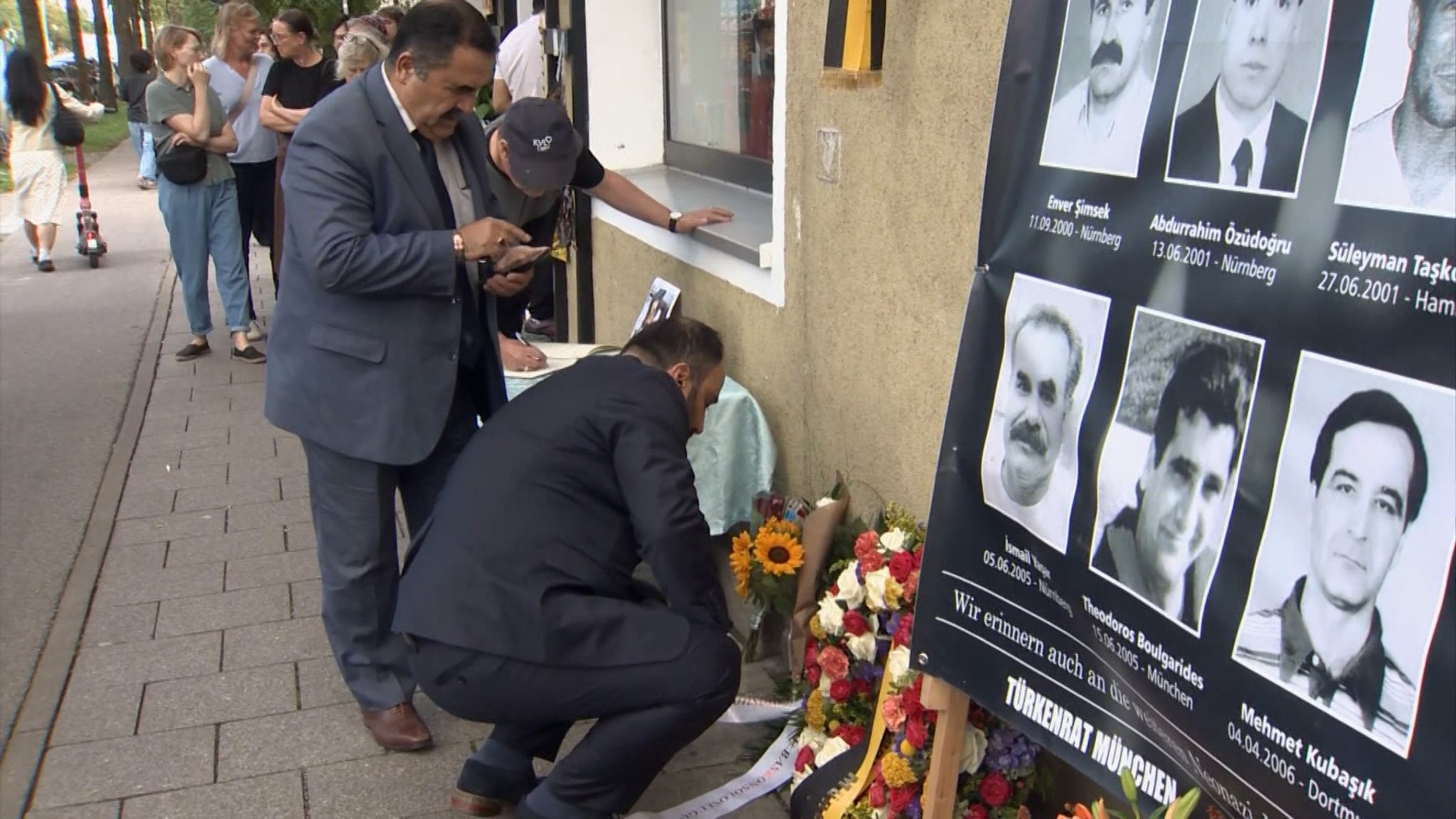 Menschen legen an der Gedenkstelle in München-Ramersdorf Blumen nieder für die vom rechtsextremistischen NSU ermordeten Opfer. | Bild: BR24 Menschen legen an der Gedenkstelle in München-Ramersdorf Blumen nieder für die vom rechtsextremistischen NSU ermordeten Opfer.
