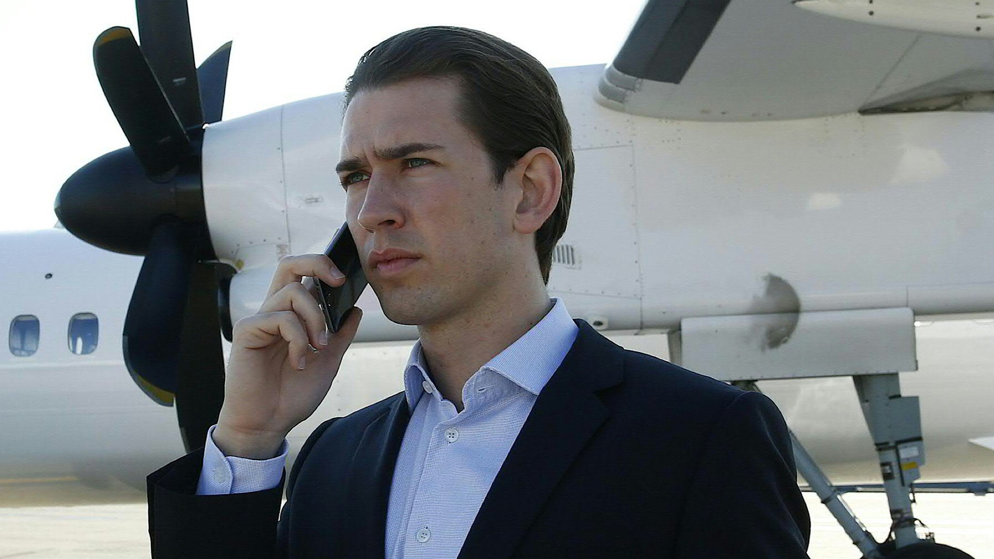 Sebastian Kurz telefoniert vor einem Flugzeug