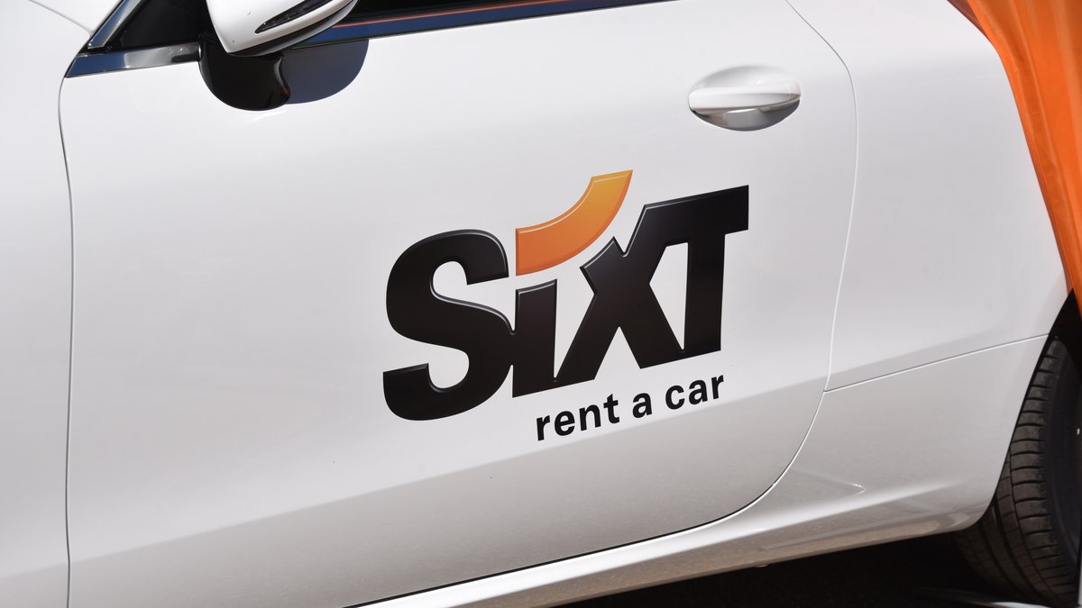 Logo Schriftzug des Autovermieters SIXT auf einem Auto.