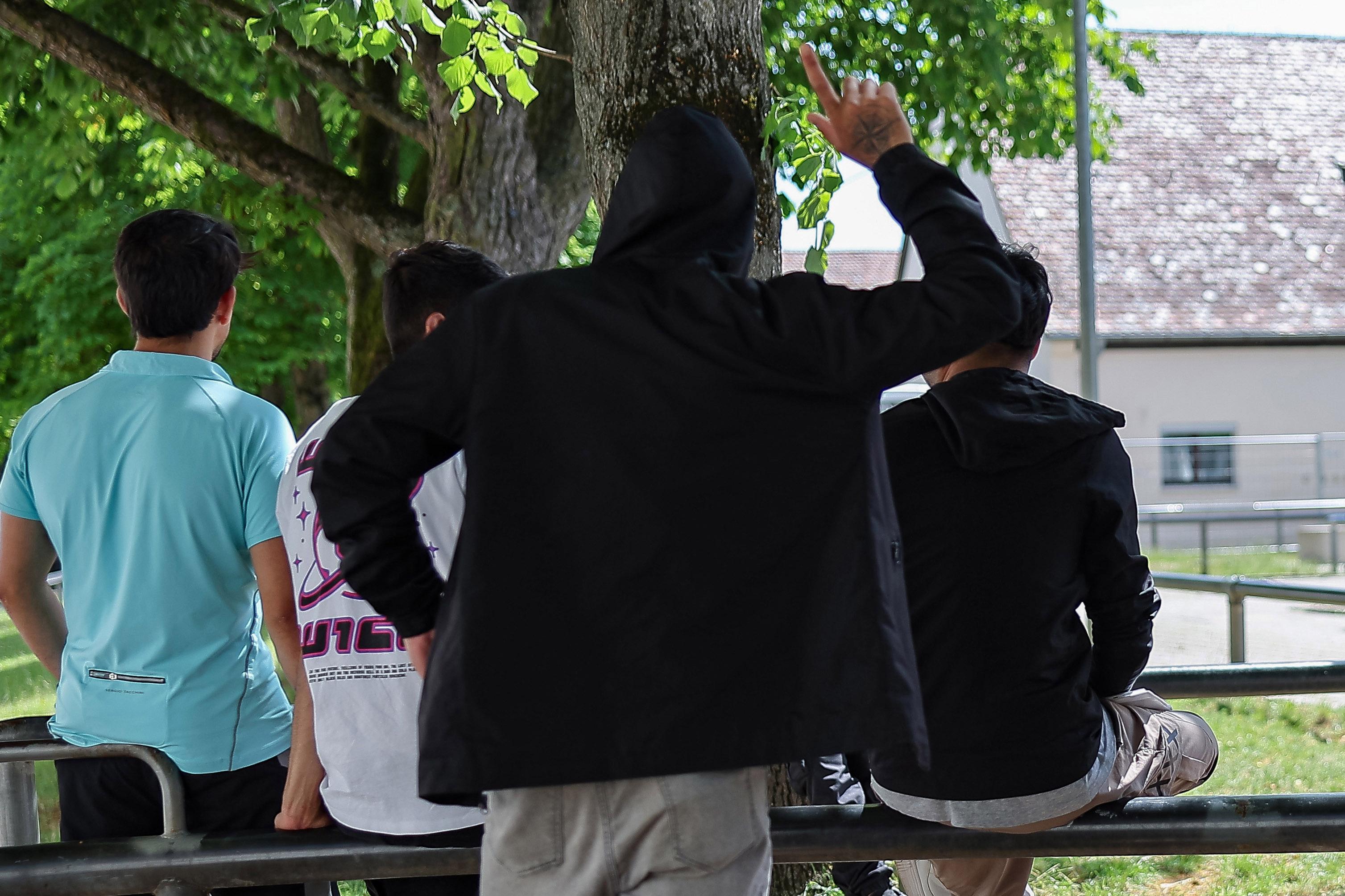 Ein Gruppe von Flüchtlingen oder Migranten lehnen in der Zentralen Aufnahmeeinrichtung für Asylbewerber in Bayern an einem Geländer.