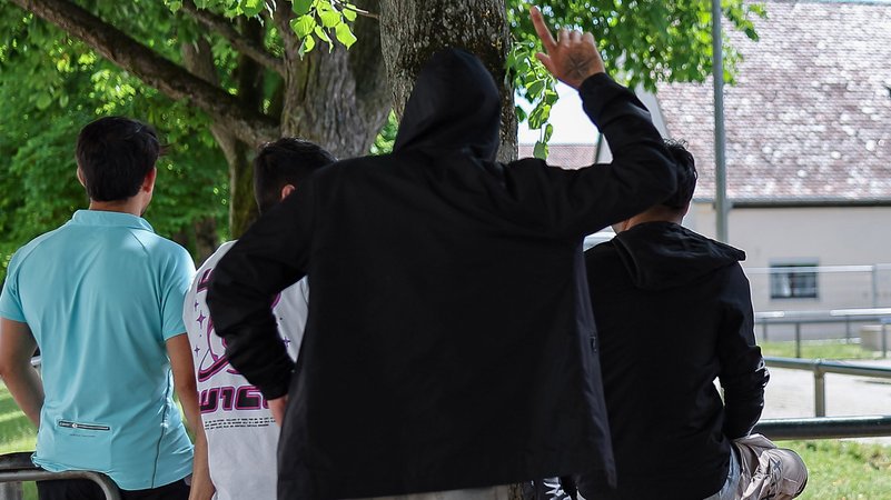Ein Gruppe von Flüchtlingen oder Migranten lehnen in der Zentralen Aufnahmeeinrichtung für Asylbewerber in Bayern an einem Geländer. | Bild: picture alliance/dpa | Daniel Löb Ein Gruppe von Flüchtlingen oder Migranten lehnen in der Zentralen Aufnahmeeinrichtung für Asylbewerber in Bayern an einem Geländer.