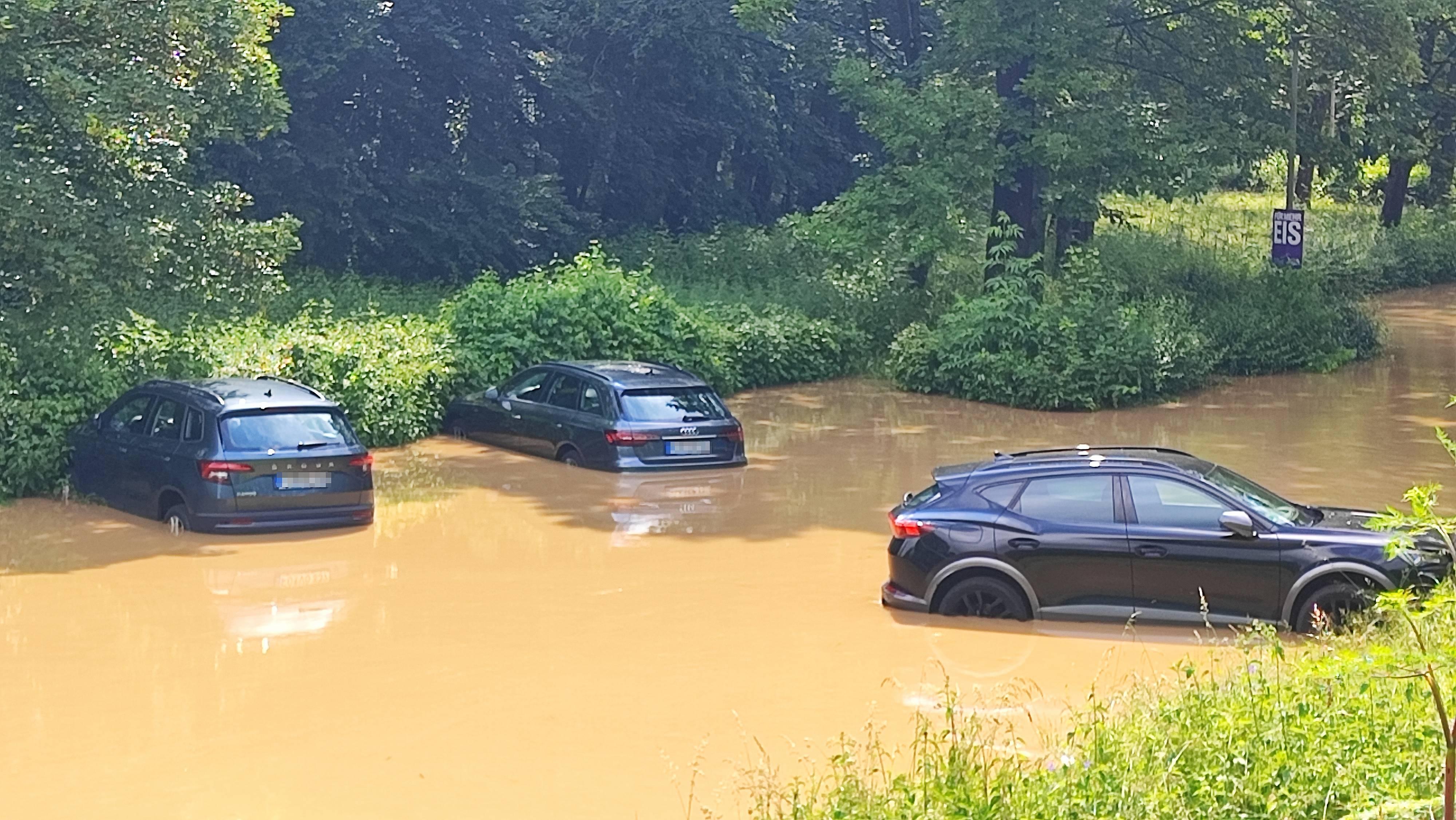 Autos auf einem überfluteten Parkplatz in Volkach