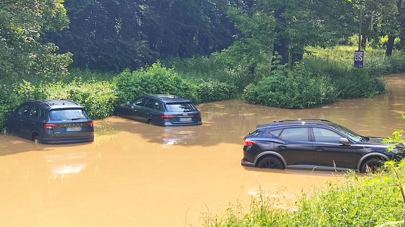 Autos auf einem überfluteten Parkplatz in Volkach