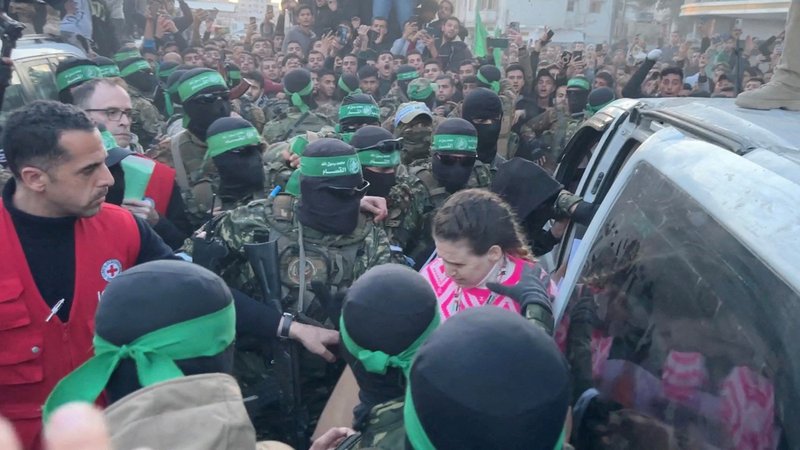 Der Moment der Übergabe: Hamas-Kämpfer geleiten die drei Geiseln zur Übergabe an das Rote Kreuz | Bild: REUTERS/via Reuters Der Moment der Übergabe: Hamas-Kämpfer geleiten die drei Geiseln zur Übergabe an das Rote Kreuz