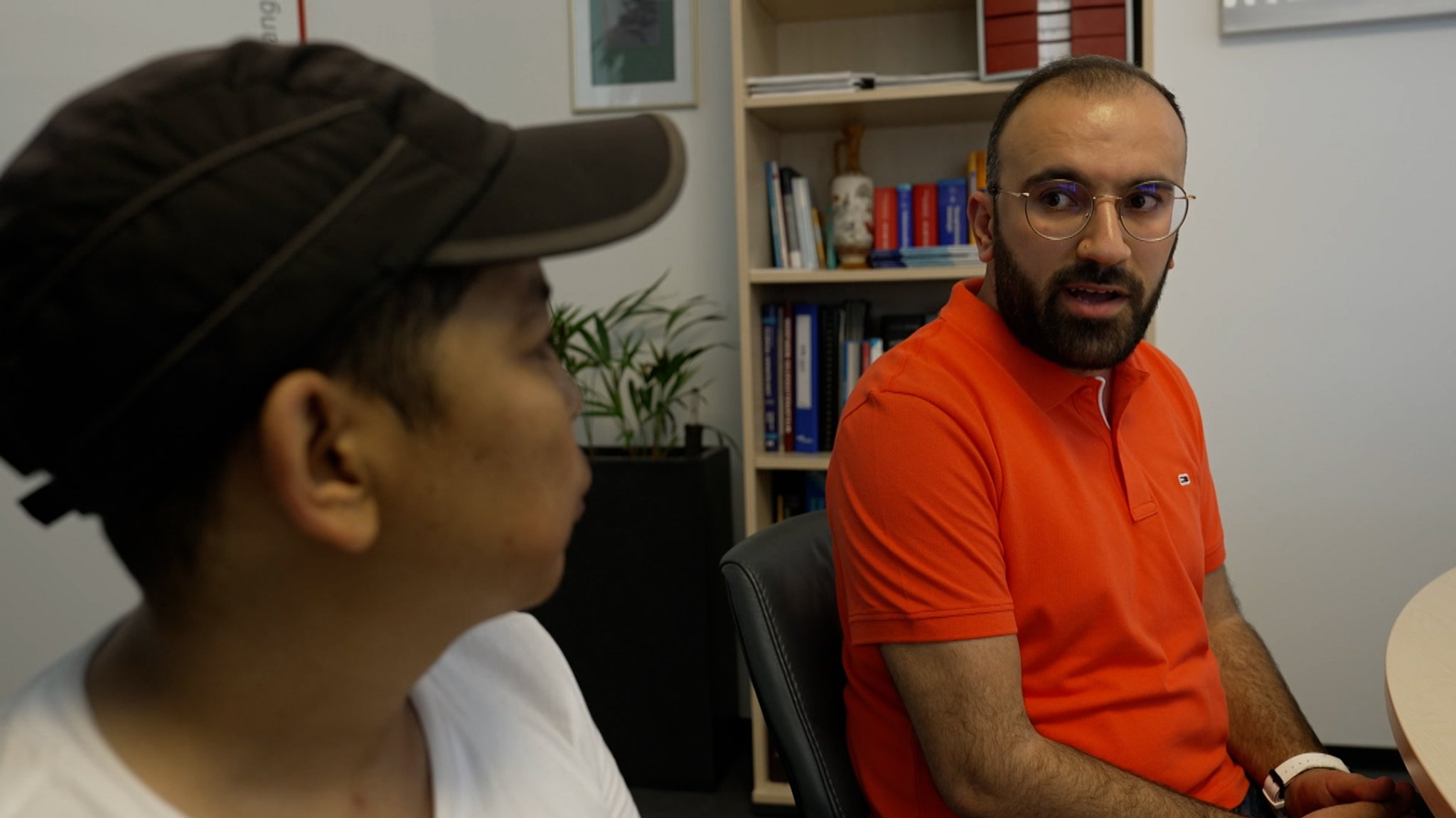 Ein Dolmetscher unterstützt einen Migranten beim Arzt.