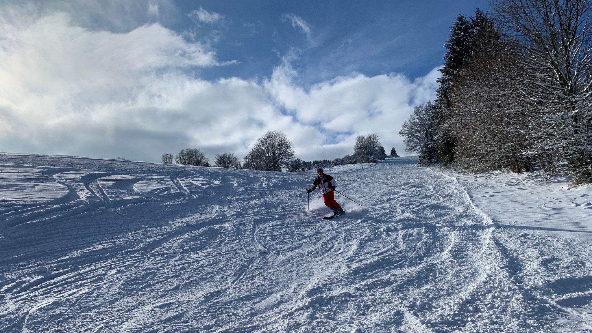 Ein Skifahrer fährt in der Rhön einen Hang hinab.