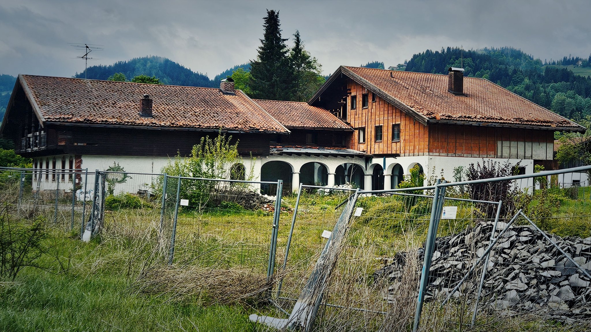 Ehemaliger Gasthof „Sachranger Hof“ verfällt in Sachrang hinter einem Bauzaun. 