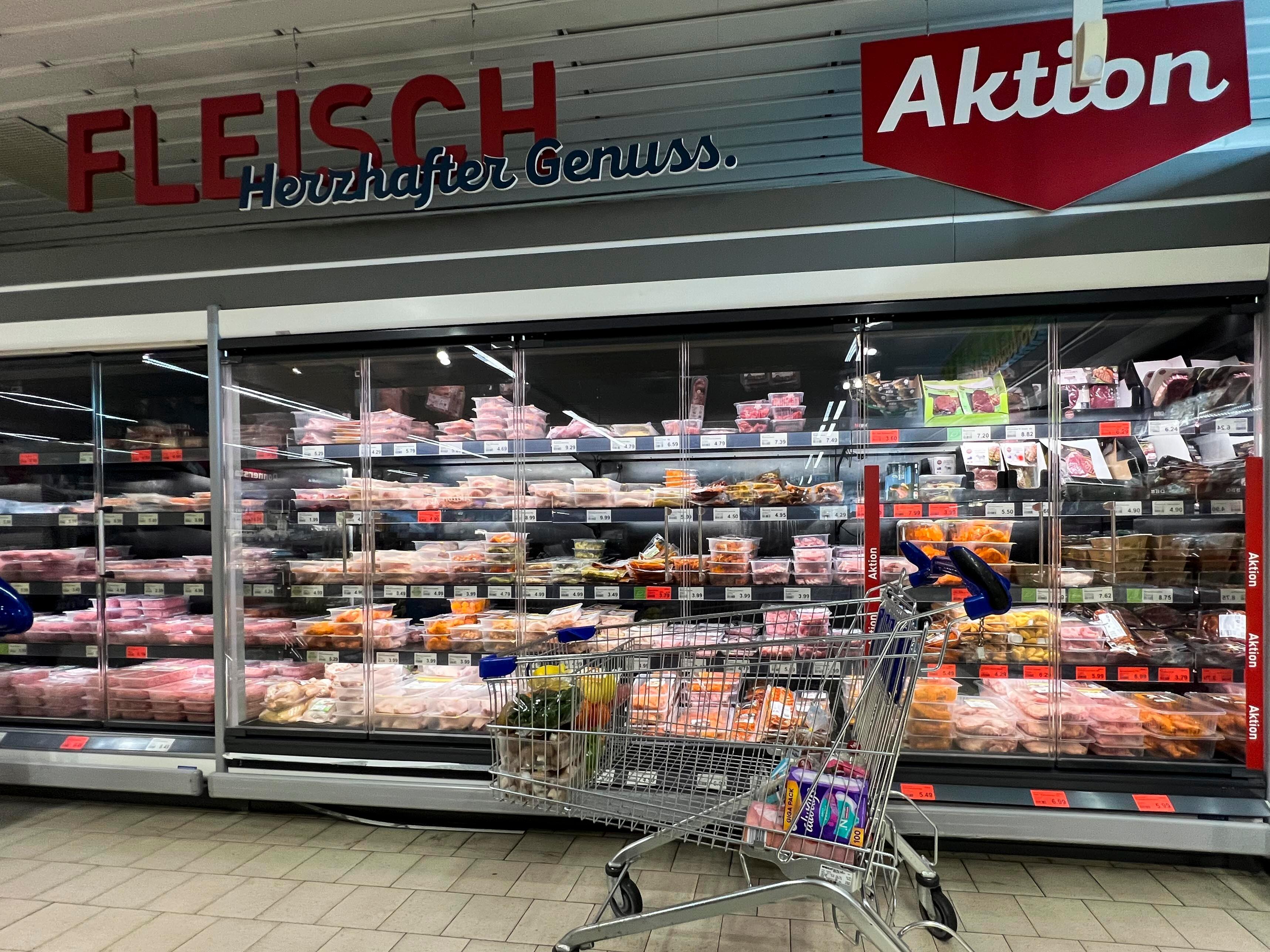 Ein Einkaufswagen vor verschiedenen Fleisch- und Geflügelwaren